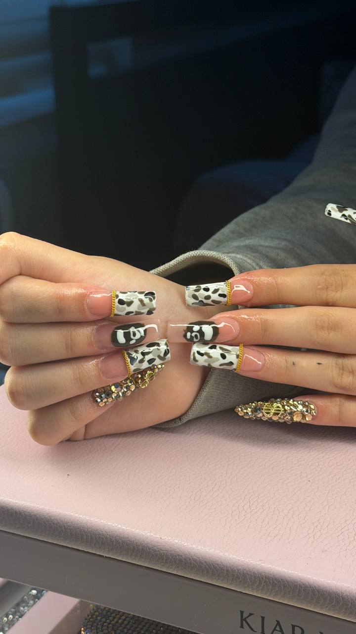 Cow print nails with gold chain accents by Tay